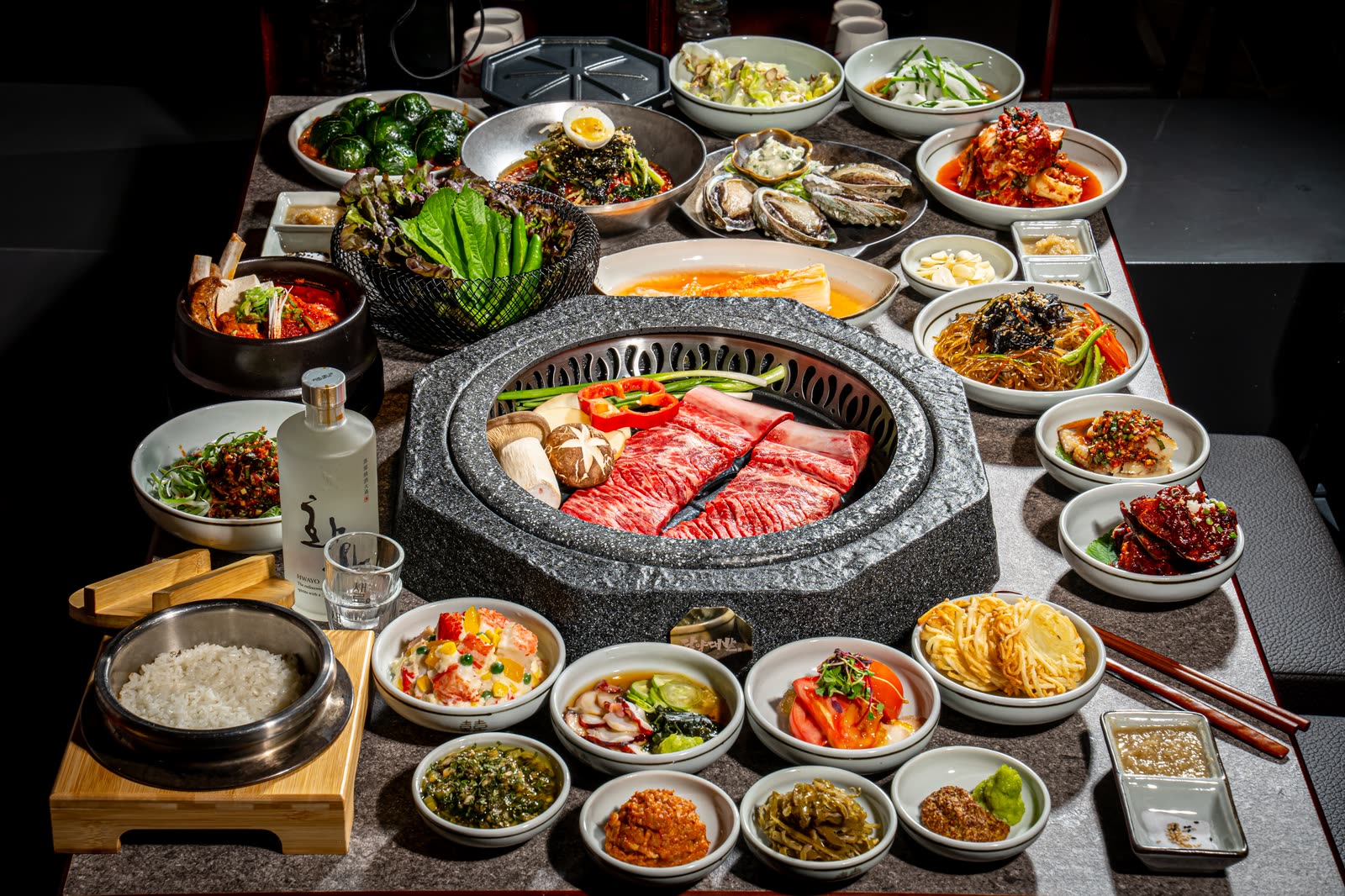 숯불 위의 고기와 여러 반찬이 함께 차려진 담양대밭 명동점의 테이블
