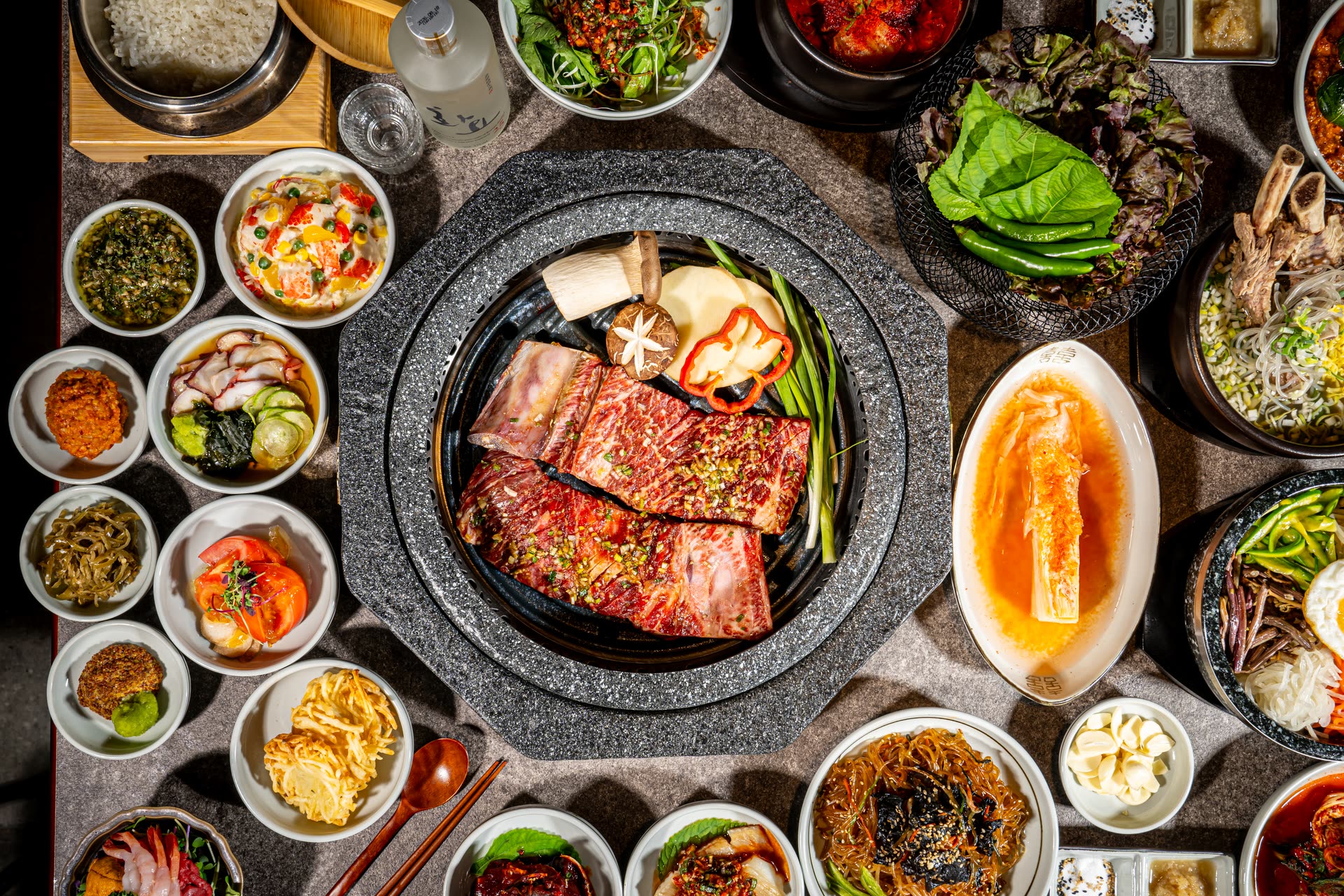 위에서 내려다본 담양대밭 명동점의 한상차림 — 숯불 돌판을 둘러싼 반찬과 국, 밥